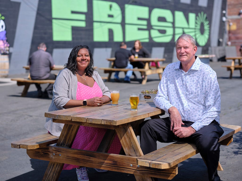 Smiling Individuals Sitting At Picnic Table in Fresno