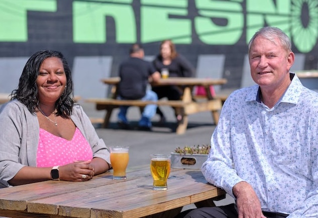 Smiling Individuals Sitting At Picnic Table in Fresno